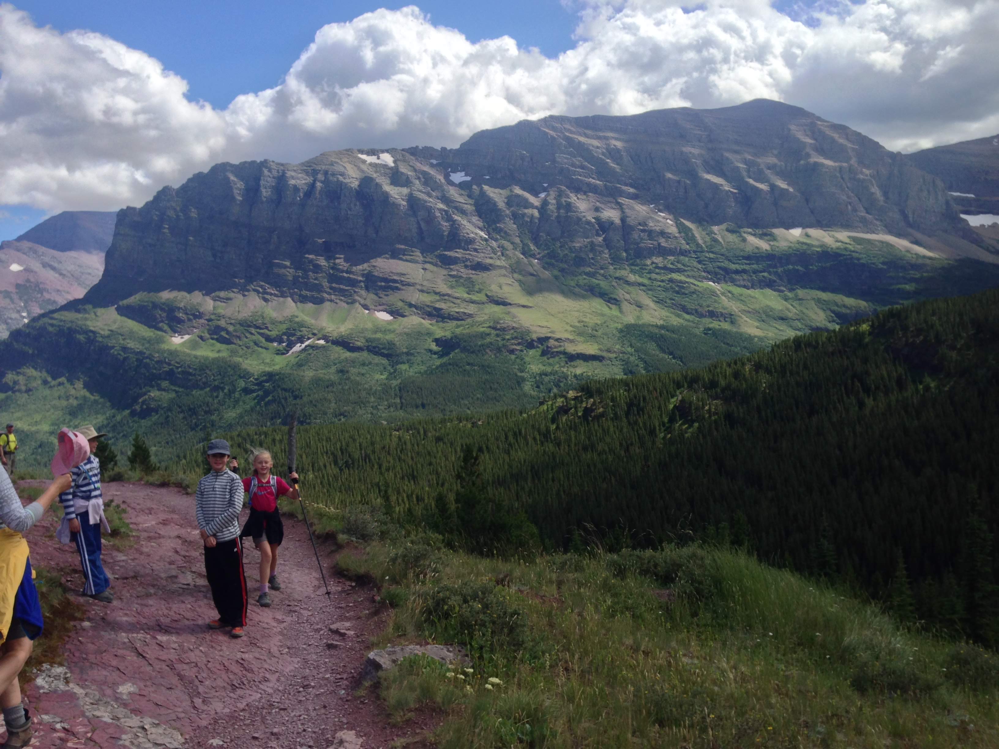 people walking on trail with mountains in background13